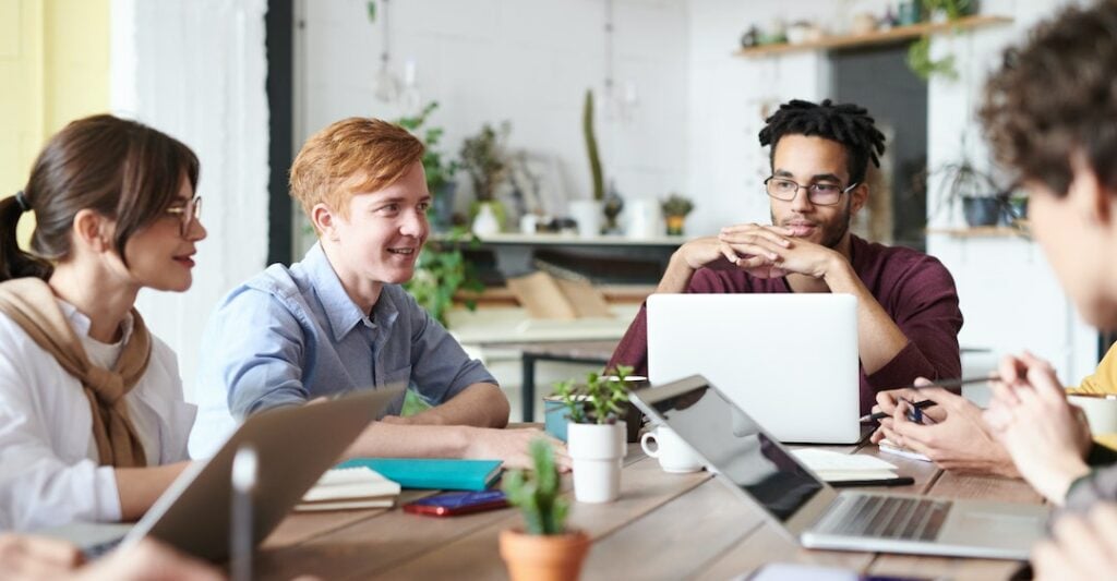 Diverse coworkers using Certn background checks on laptop