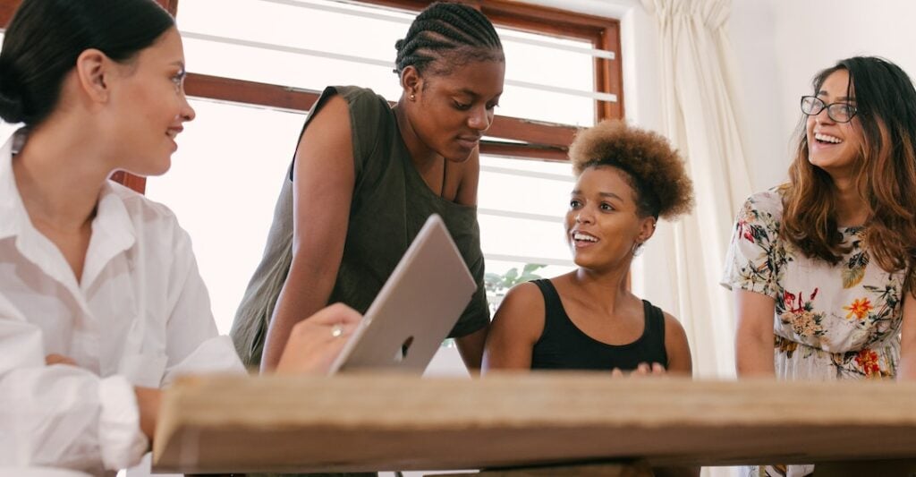 Smiling women employees reviewing essential background check results on laptop