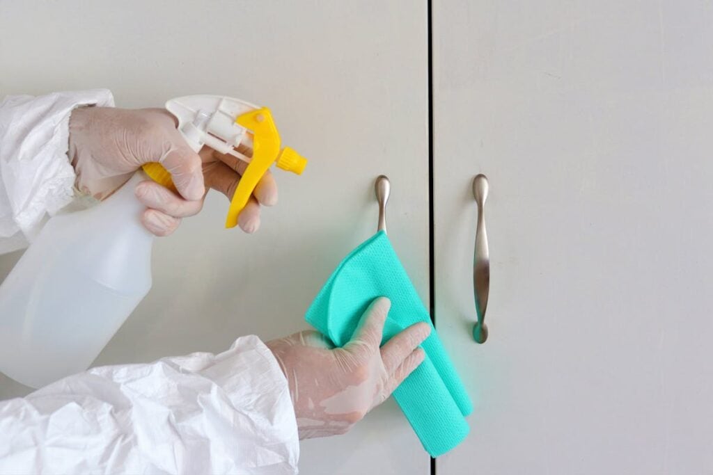 Cleaning person wiping bathroom representing checks to protect your cleaning business