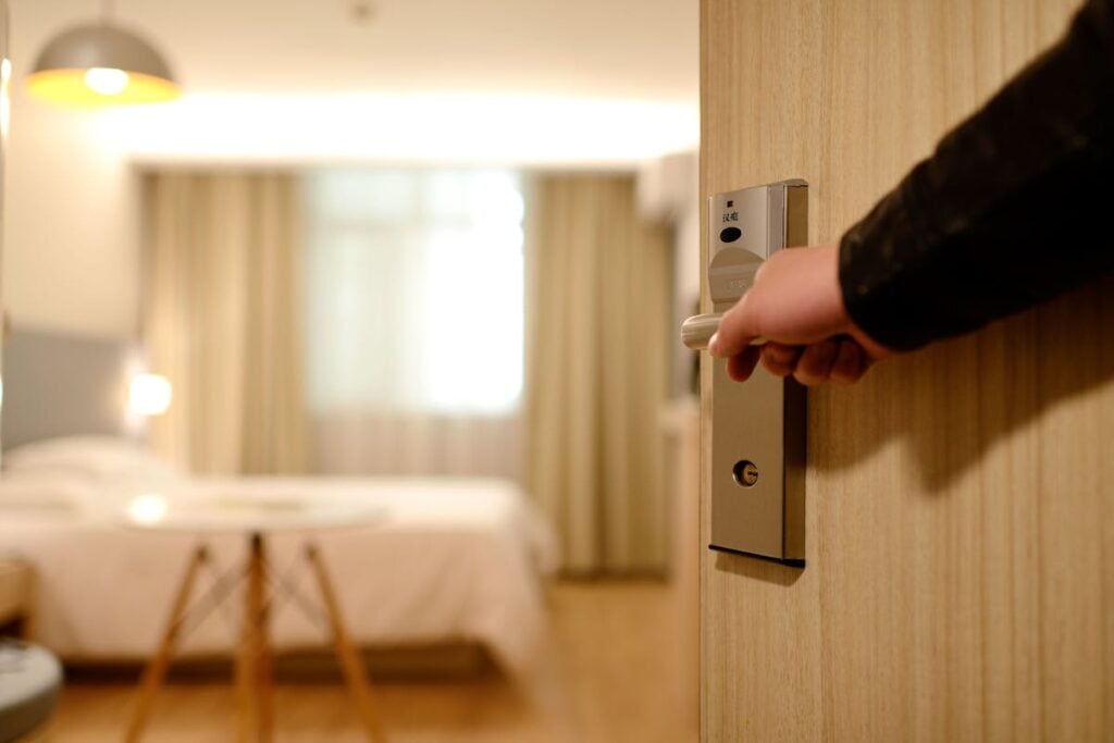 Attendant opening hotel room door representing hotel hiring in 2025