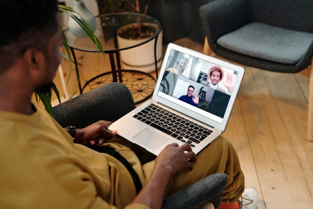 Diverse colleagues working remotely on laptop representing benefits of rescreening for global teams