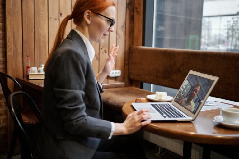 Female HR leader taking remote meeting on laptop representing benefits of rescreening for remote teams